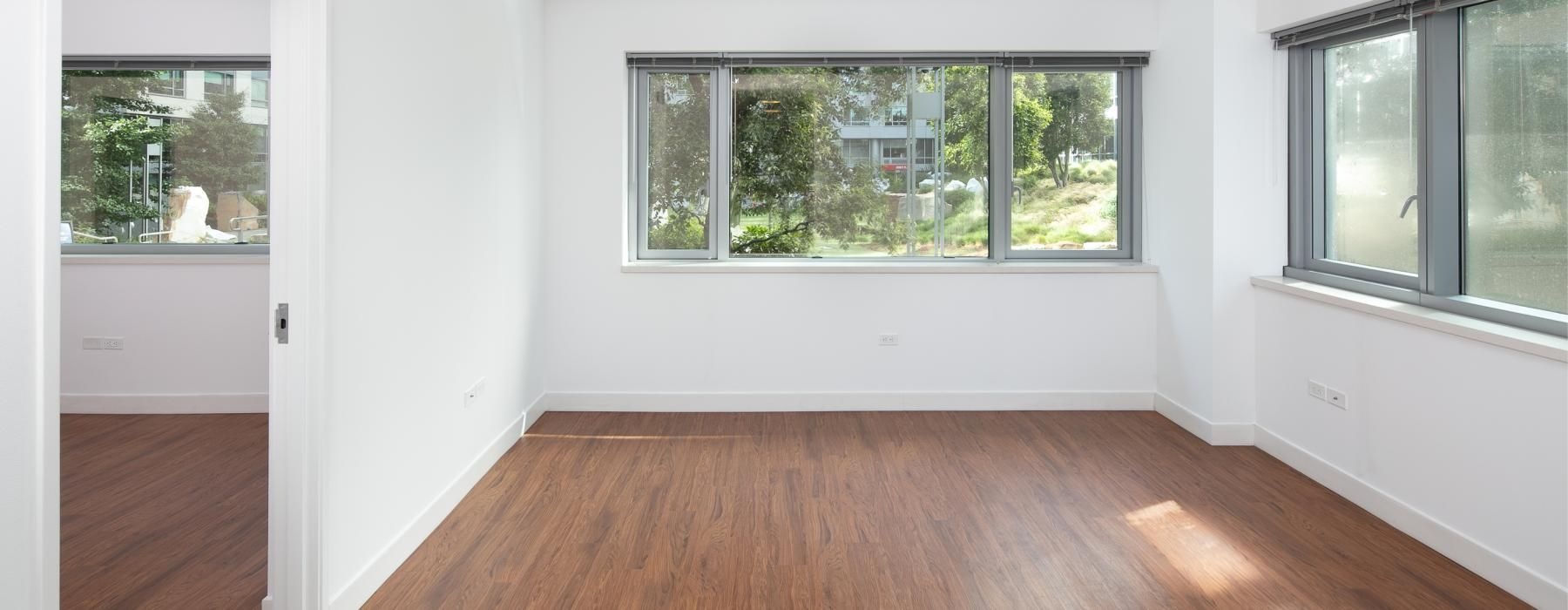 a room with a wood floor and windows